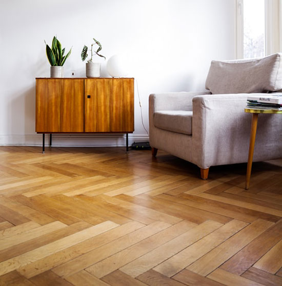 Floor wood planks successfully acclimated in a living room with white sofa and wooden cupboard as we recap the best practices