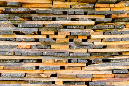 Unpacked and cross-stacked wood planks at construction site, in order to acclimate them much faster by maximizing the airflow