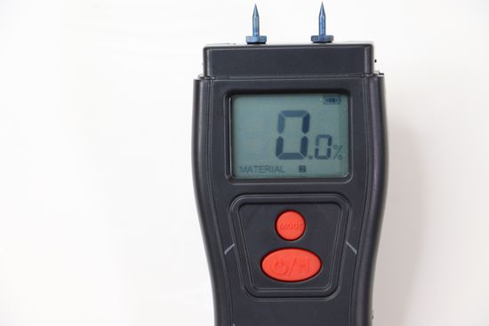 A black pin moisture meter with a reading of 0 MC.