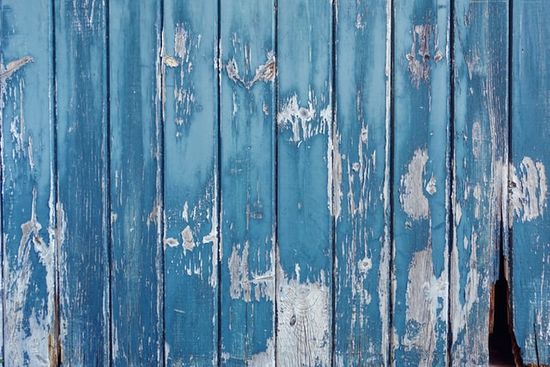 Teal wooden boards with peeling paint and other damage, as we discuss the importance of a moisture meter