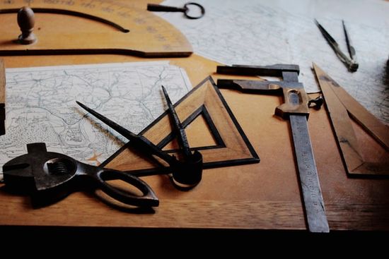 An assortment of measuring tools for woodworking, including a triangle-shaped speed square