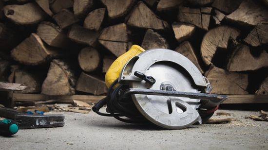 A circular saw lying near a stack of wood
