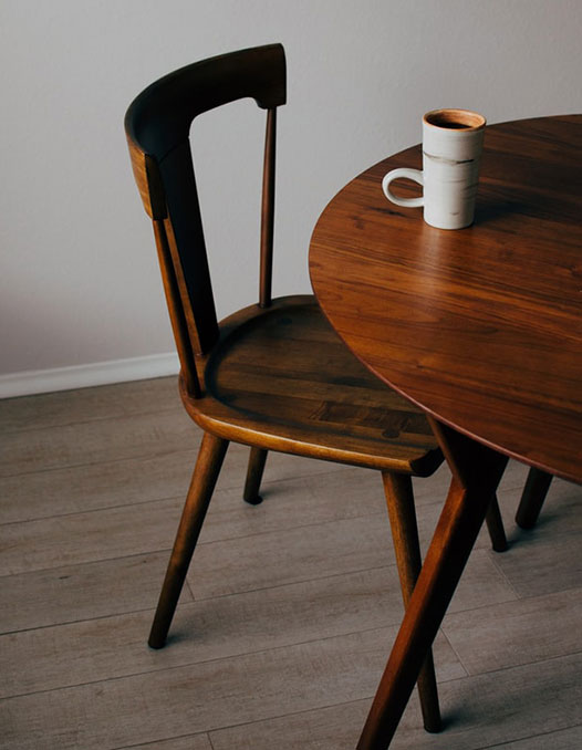 A round wooden table and chair with turned table legs that may be difficult to measure with a pinless moisture meter
