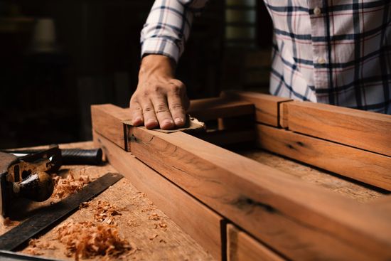 A woodworker sanding some boards