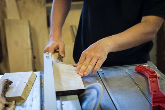 A woodworker using a circular saw to cut a piece of wood