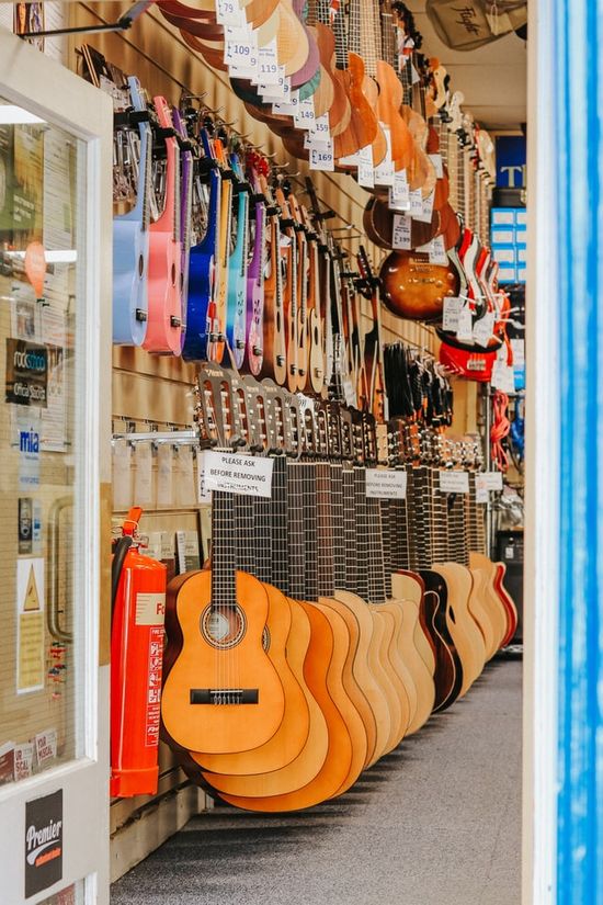 Guitars and ukuleles hanging in a musical instrument shop