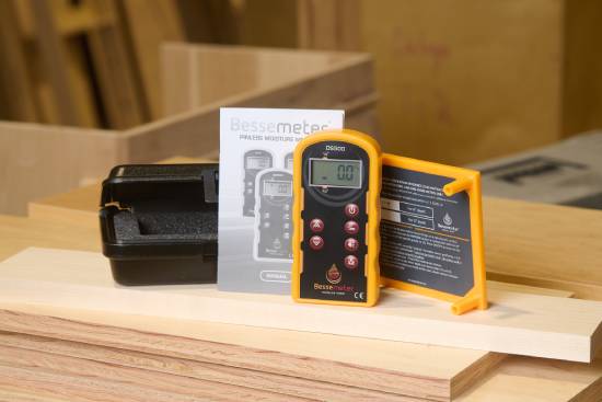 A Bessemeter kit with meter, calibration verification device, manual, and case nicely positioned on a stack of wood planks.