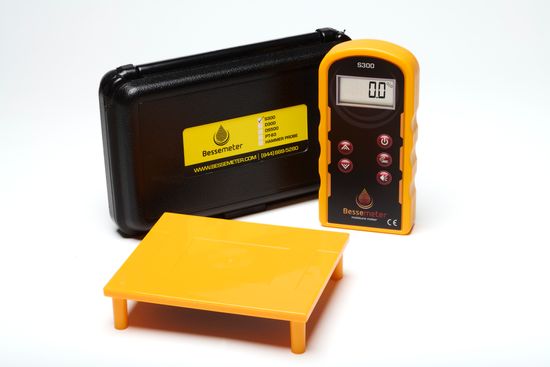 A Bessemeter moisture meter with a black case and a yellow calibration verification reference