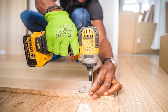 A flooring specialist replacing damaged hardwood flooring