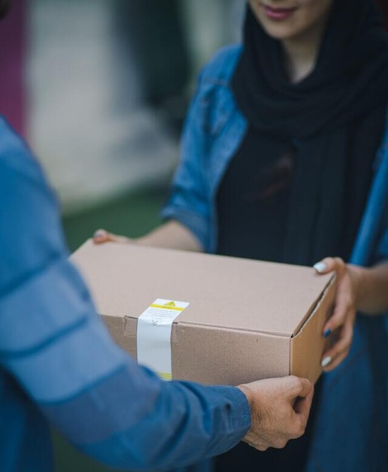 A woman holding a package to send her moisture meter to the manufacturer