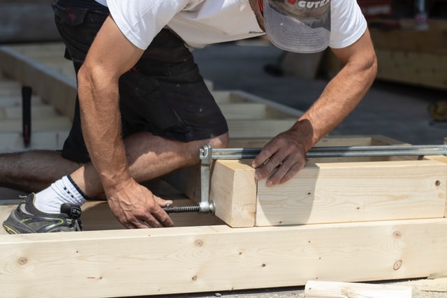 A construction worker building a wooden frame