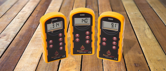 Three wood moisture meters sitting on a wood counter