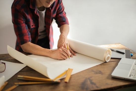 A woodworker drawing plans for a woodworking project