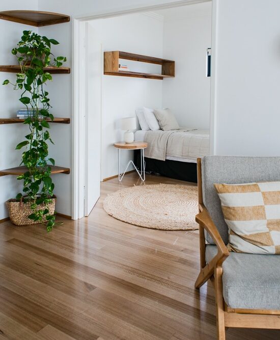 A door open to a bedroom that has a hardwood floor