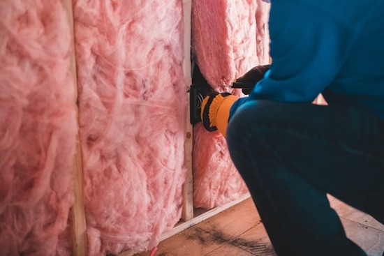 A builder installing insulation in the wall of a kiln