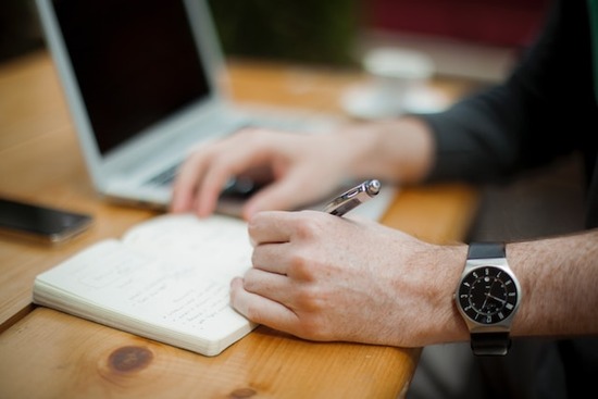 A person writing a woodworking plan