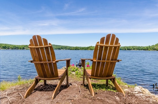 Wooden Adirondack chairs looking out on a lake