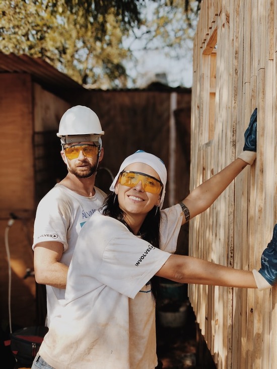 Two hobbyist woodworkers constructing a shed