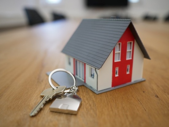 A miniature house with a set of house keys next to it