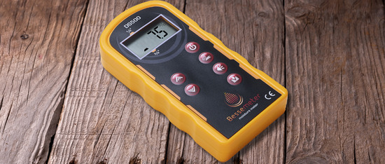 A Bessemeter wood moisture meter on a hardwood floor
