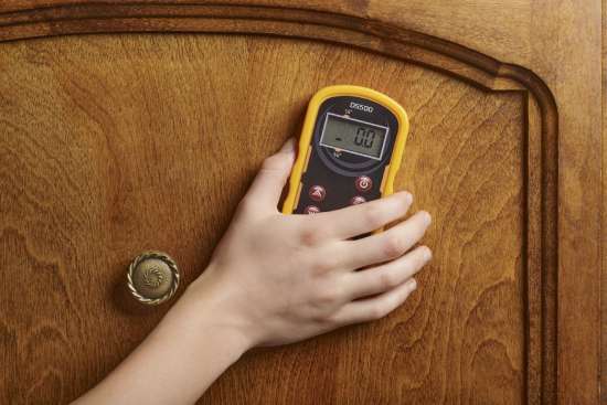 A non-damaging meter taking readings on a wooden cabinet