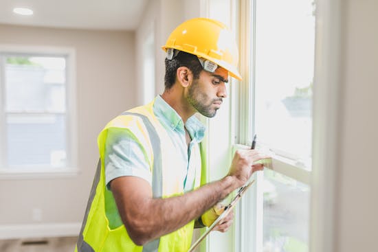 Home inspector checking a window frame for moisture intrusion