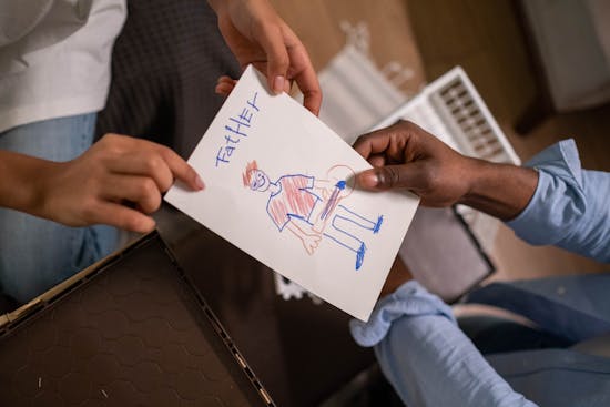 A child giving their father a Father's Day card
