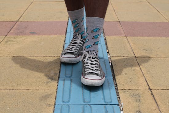 A man wearing popsicle-patterned socks with sneakers