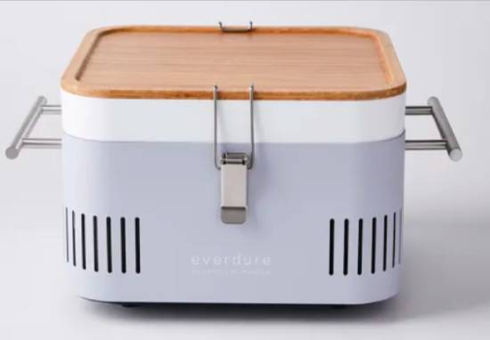 A portable grill with metal handles and a wooden lid