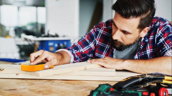  A woodworker testing a board's moisture content with a Bessemeter moisture meter.