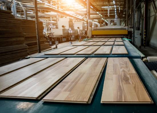 A conveyor belt at a flooring manufacturer factory carrying engineered floorboards